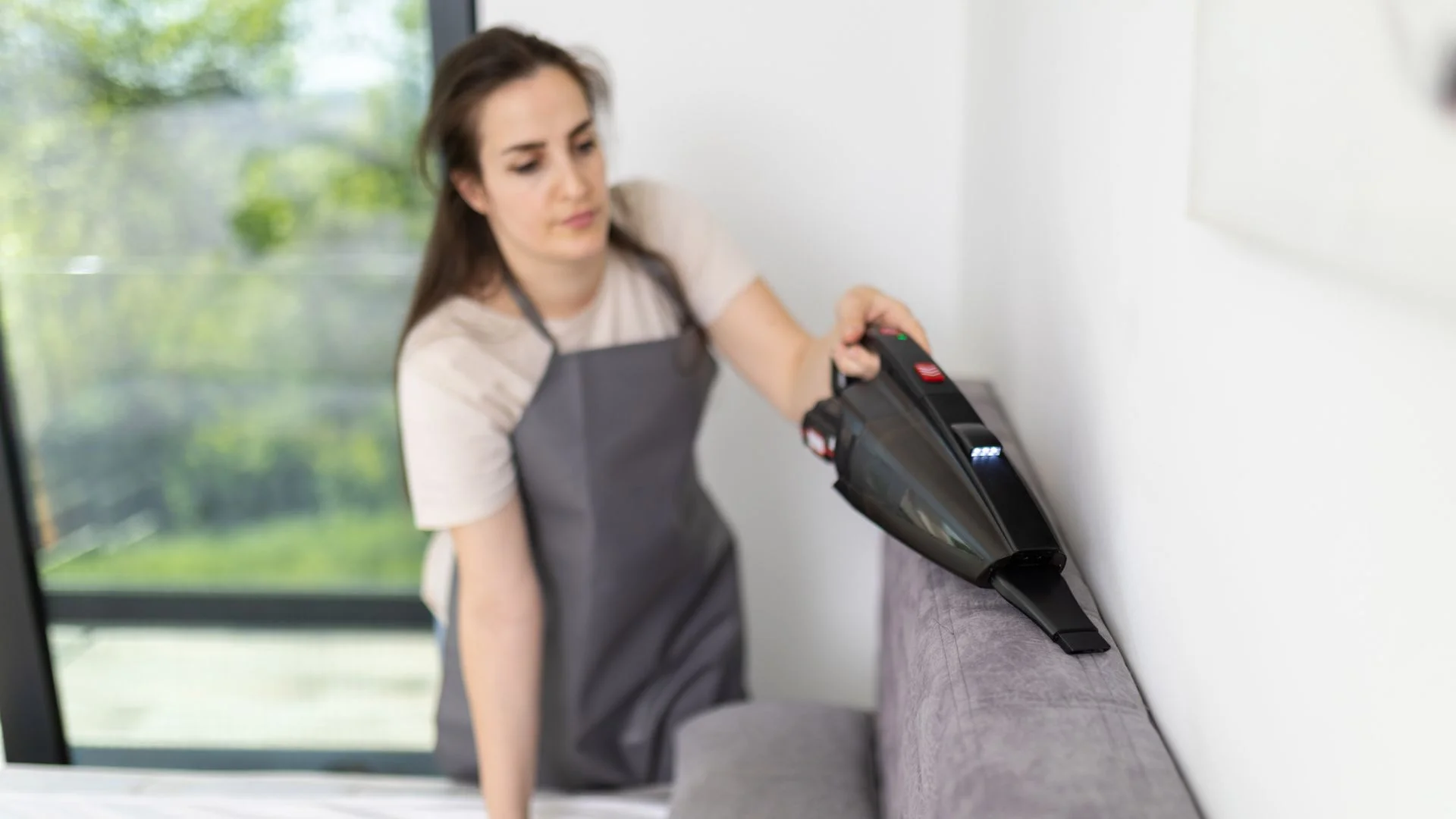 Woman vacuuming bedframe