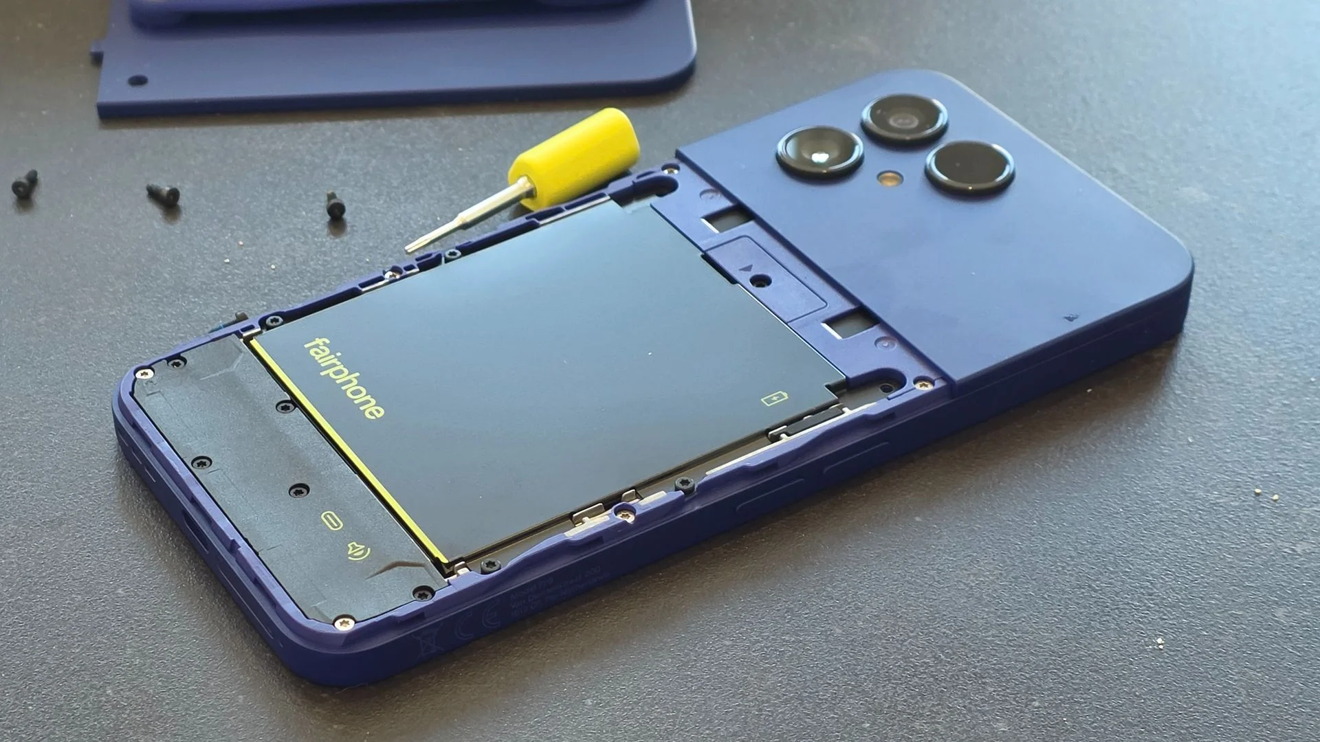 The Fairphone Gen 6 Plus resting on a black table