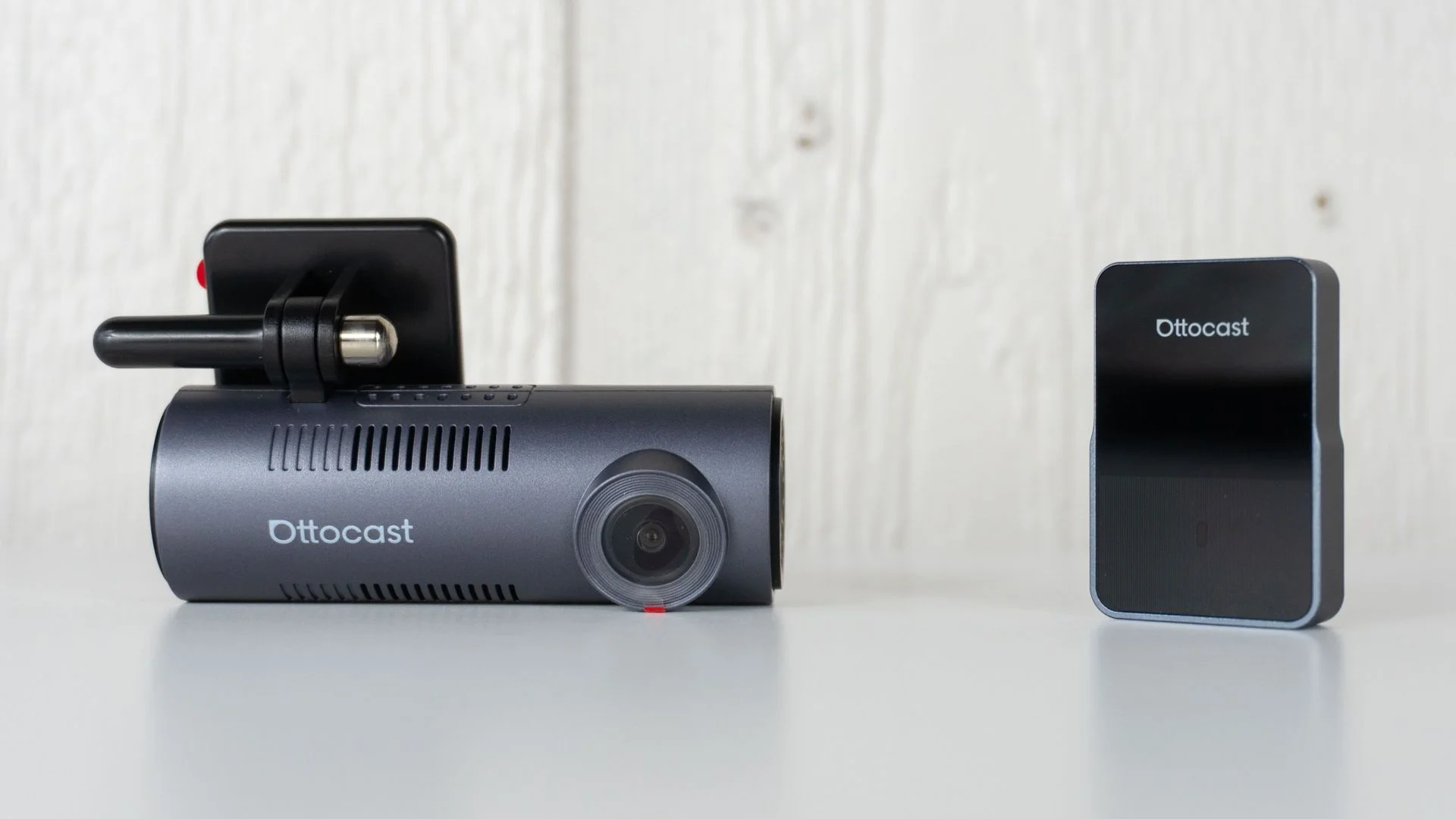 The Ottocast OttoSafe Cam's dashcam and wireless adapter next to each other on a table
